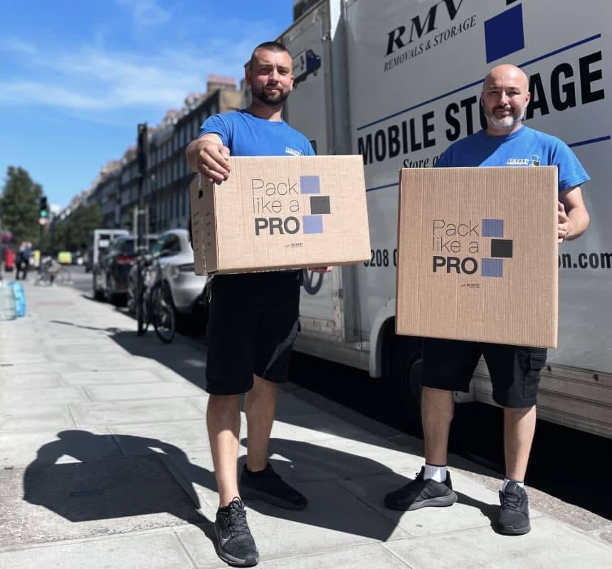 Two RMV movers holding packed Pack Like a PRO boxes beside the RMV van in London