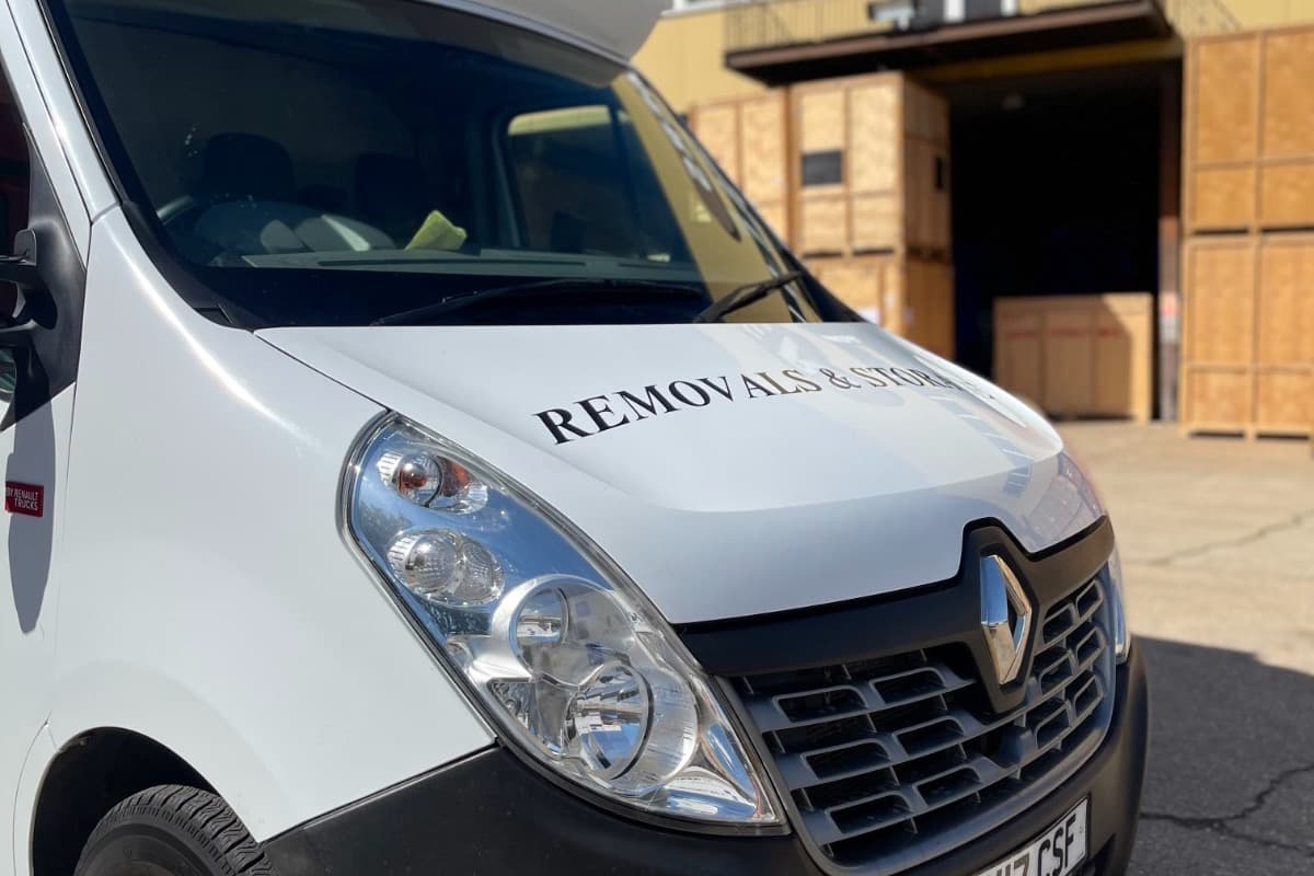 Front of a white RMV removal van parked outside the storage warehouse