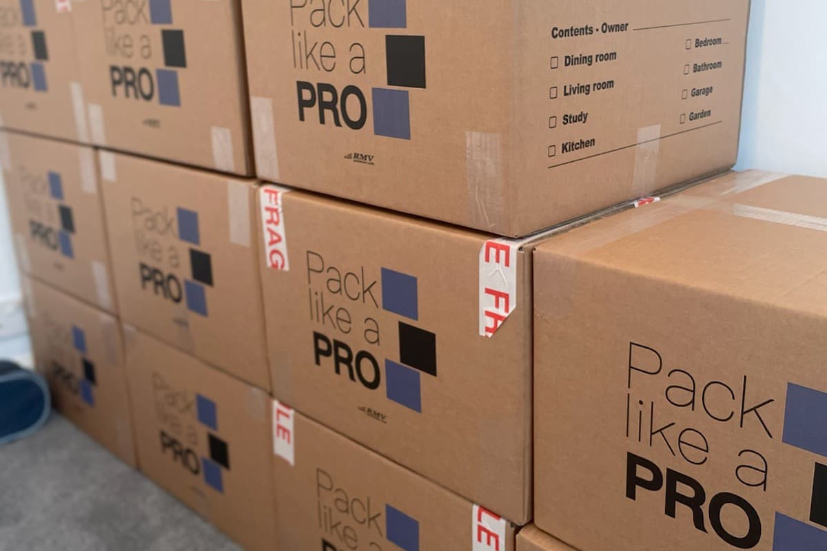 Wall of packed and taped Pack Like a PRO moving boxes stacked high
